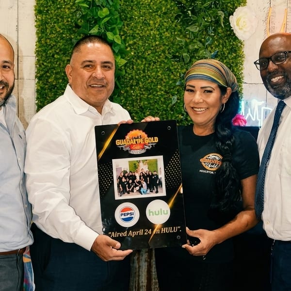 Four smiling people, two men and two women, holding a "Guadalupe Gold" award plaque.